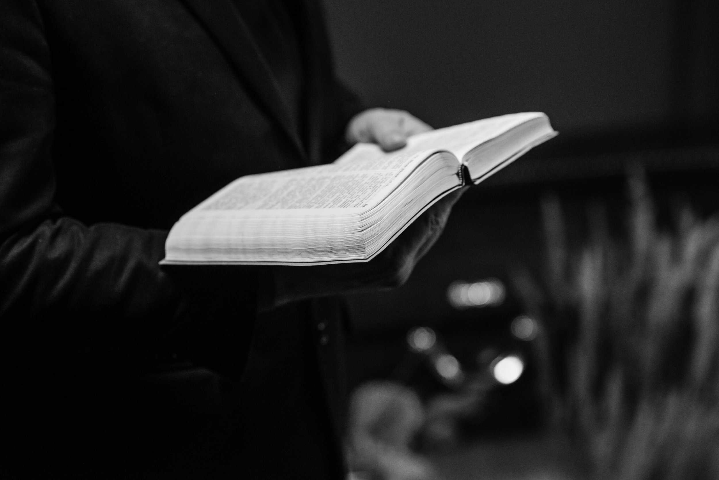 person holding an opened Bible